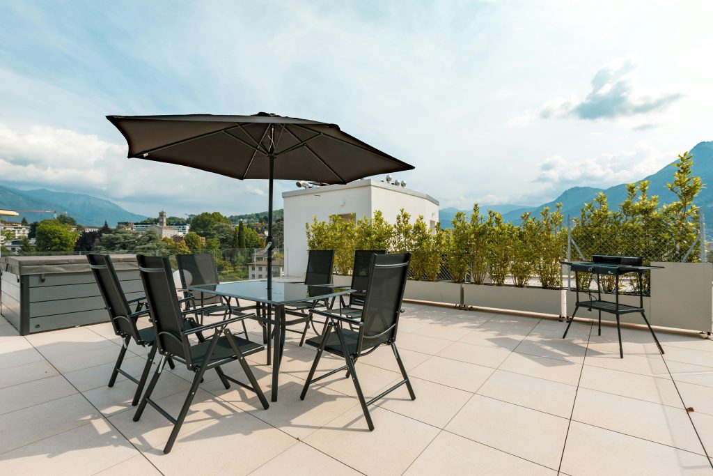 Sunny terrace with furniture, umbrella, and mountain views. Ideal for outdoor relaxation.