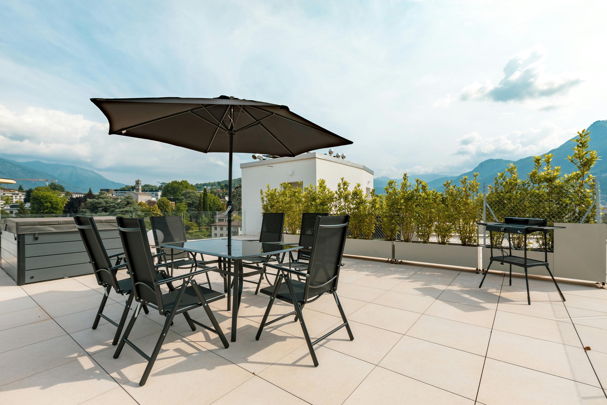 Sunny terrace with furniture, umbrella, and mountain views. Ideal for outdoor relaxation.
