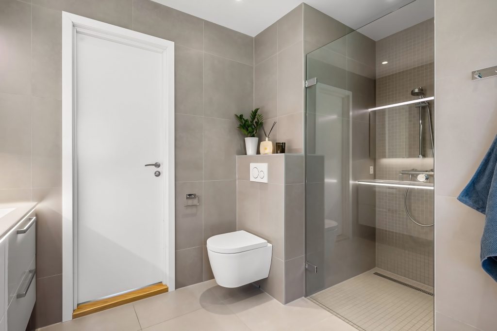 Sleek minimalist bathroom design featuring a glass shower enclosure and floating toilet.